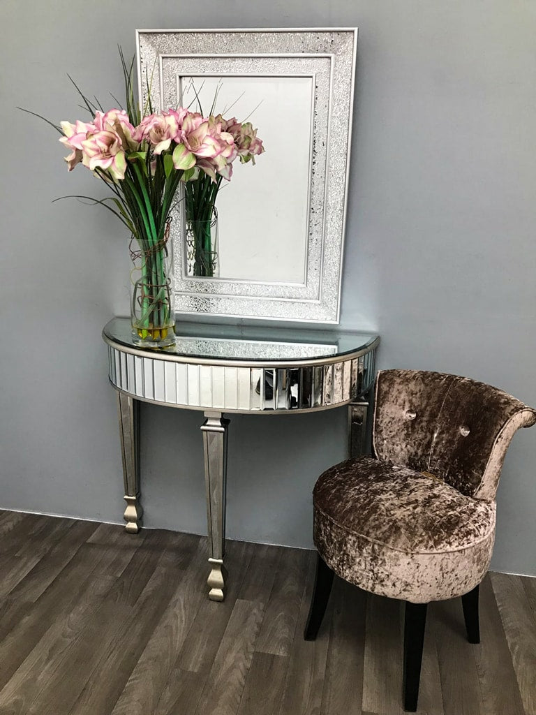Half Moon Mirrored Console Table arranged with flower vase, velvet chair and wall mounted mirror
